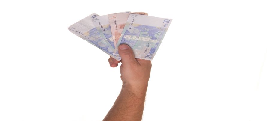 Mano sosteniendo un puñado de billetes