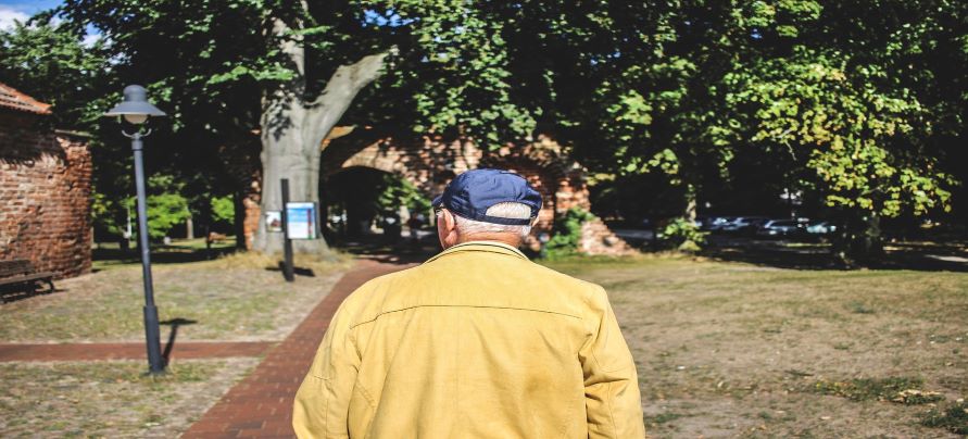 Anciano caminando por un parque
